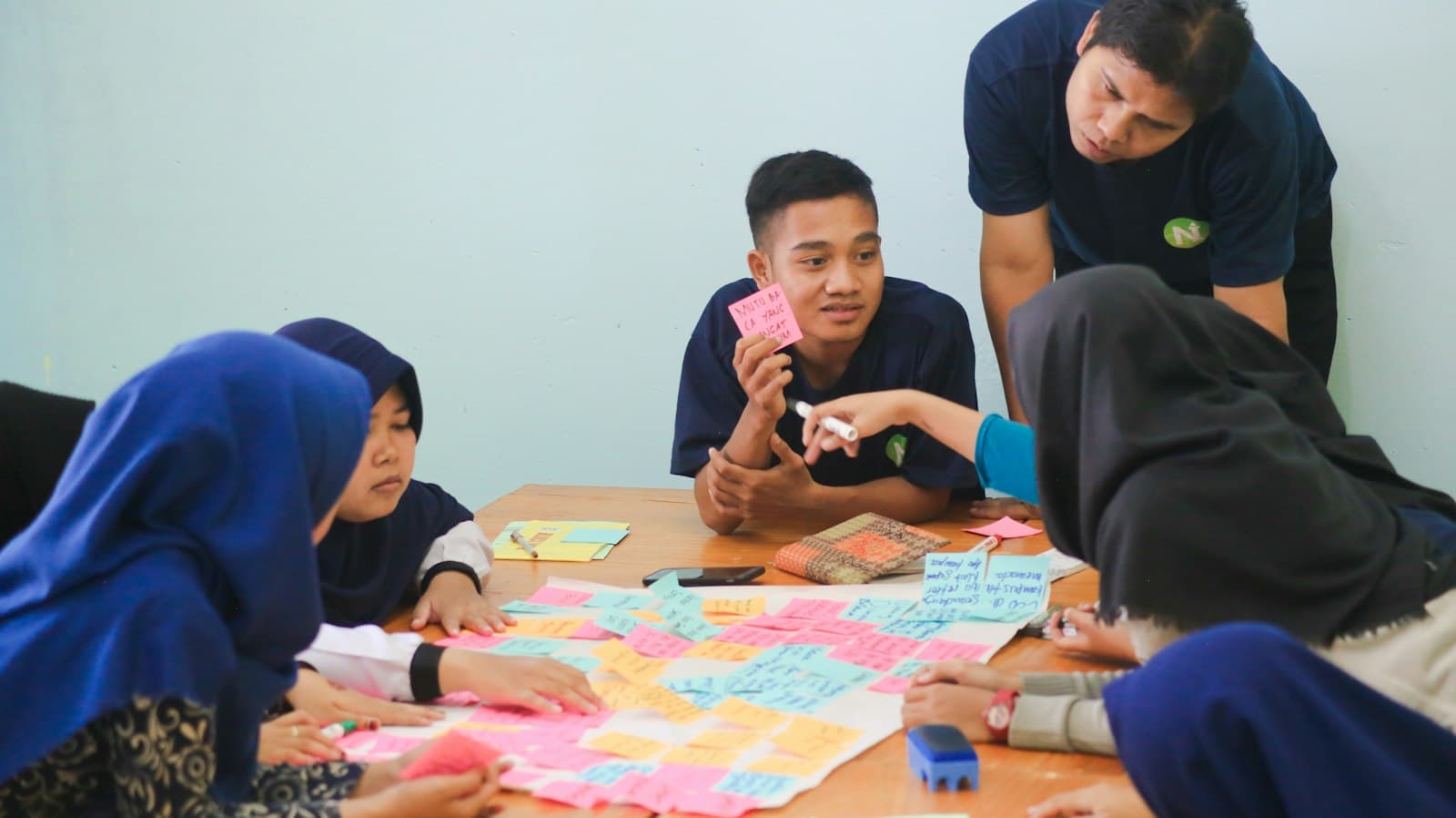Teens planning ideas with sticky notes around a table