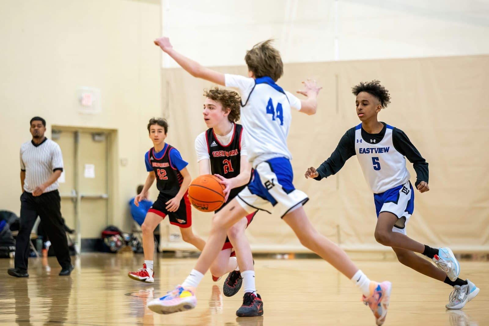 Young players driving to the hoop in an indoor basketball game