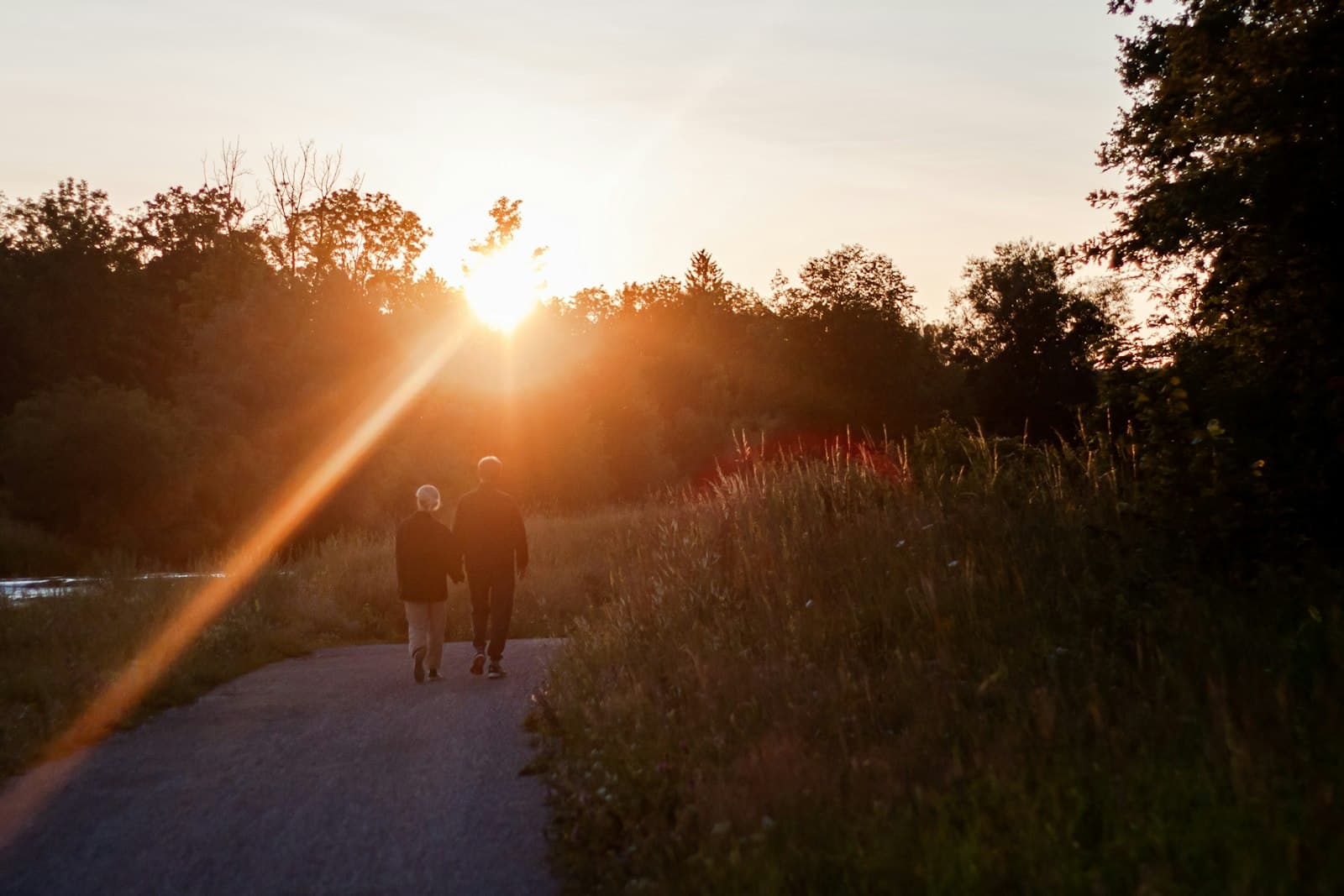Two people walking along a path at sunrise